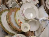 a box full of china plates and bowls on the floor
