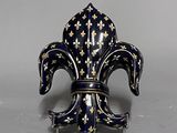 une image représentant une figurine en forme de fleur de lys bleue et dorée