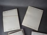 four pieces of white paper with writing on them sitting on a table
