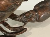 a bronze statue of a lobster and a crab on a checkered floor