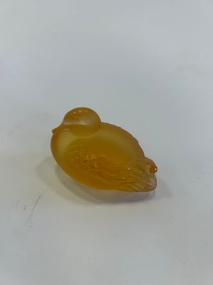 a small yellow bird sitting on top of a white surface