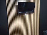 une télévision fixée au mur dans un coin de la pièce