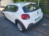 a small white car parked on the side of the road