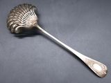 a silver spoon with a leaf shaped handle on a black surface