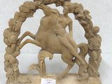 a statue of a woman riding a horse with a bird on its back