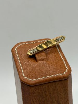 a gold tie bar sitting on top of a wooden box