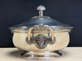 a large silver bowl with a lid on a table