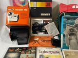 many different types of cameras and books on the table