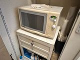 a microwave sitting on top of a cabinet in a small room