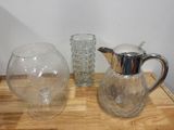 trois vases en verre et un pichet en verre posés sur une table