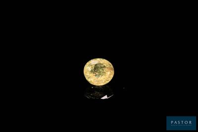 a close up of a yellow diamond on a black surface