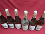 six bottles of wine are lined up on a red cloth