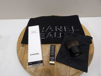 the contents of a chanel eau bag are on a wooden tray