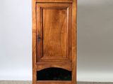 a small wooden cabinet with a door on top of it