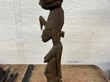 statue of a man with a hat on his head on a wooden table