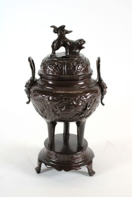 une grande urne en bronze surmontée d'un oiseau