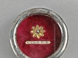 an image of a small red box with a gold flower on it