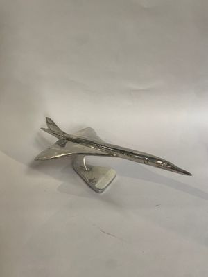 un avion argenté posé sur une surface blanche