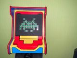 a toy arcade machine hanging on the wall