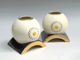 two vases with flowers on them on a stand