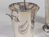 a silver ice bucket with a spoon and tongs