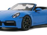 the blue porsche sports car is parked on a white surface