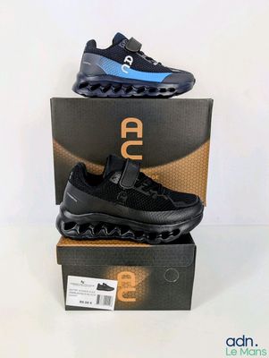 a pair of black and blue sneakers on top of a box