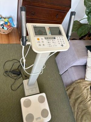 une machine blanche posée sur un lit, à côté d'un oreiller