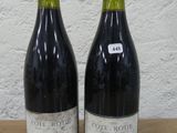 deux bouteilles de vin posées sur une table l'une à côté de l'autre