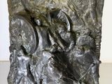 statue of a man holding a sword and a shield in a stone block