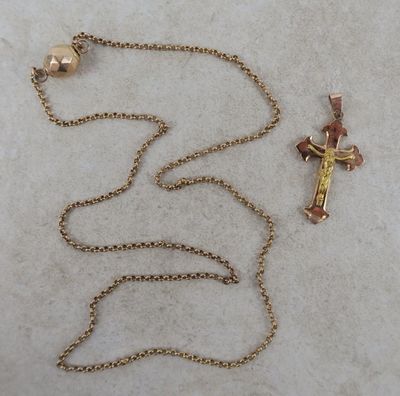 une croix et une clochette suspendue à une chaîne, posées sur une table