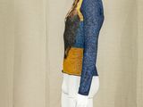 a mannequin wearing a blue and yellow top and white pants