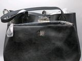 black leather handbag with a silver handle on a white background