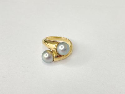 a close up of a gold ring with two pearls on it
