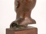 bronze bust of a young boy on a wooden base