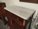 a marble top on a wooden dresser in a room