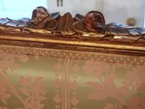 a close up of a couch with a gold frame on it