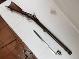 un vieux pistolet et un couteau posés sur une table dans une pièce