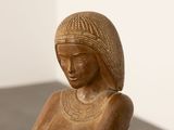 statue of a woman sitting on a stool with her hands on her knees