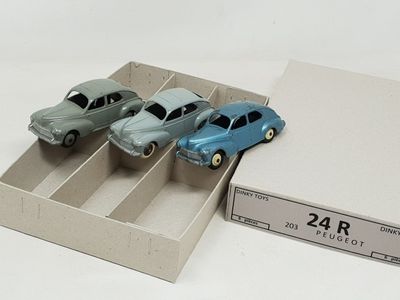 three toy cars in a box on a white surface