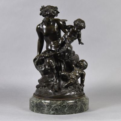 a bronze statue of a woman holding a child on a marble base