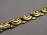 a close up of a gold bracelet on a gray surface