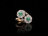 une bague en émeraude et diamant sur une surface noire