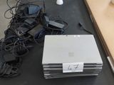 un tas d'appareils électroniques posés sur une table à côté d'une lampe