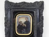 une vieille photo représentant un groupe de personnes, dans un cadre