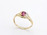 a gold ring with a ruby stone and diamonds