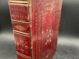 an old red book with gold writing on it