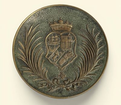 une image représentant un bouton en métal orné d'une couronne