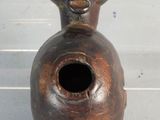 a brown vase with a face on it sitting on a table
