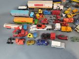 a lot of toy cars and trucks that are on the table